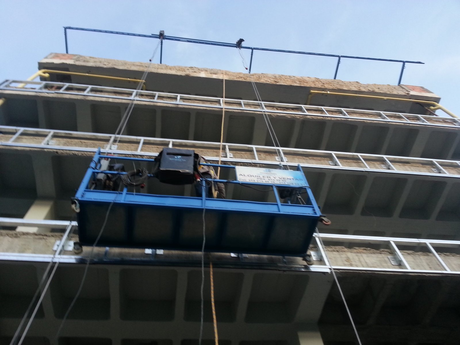 Andamio eléctrico colgante en operación en una fachada de edificio en Bogotá, sistema certificado CYMS bajo Resolución 4272 de 2021